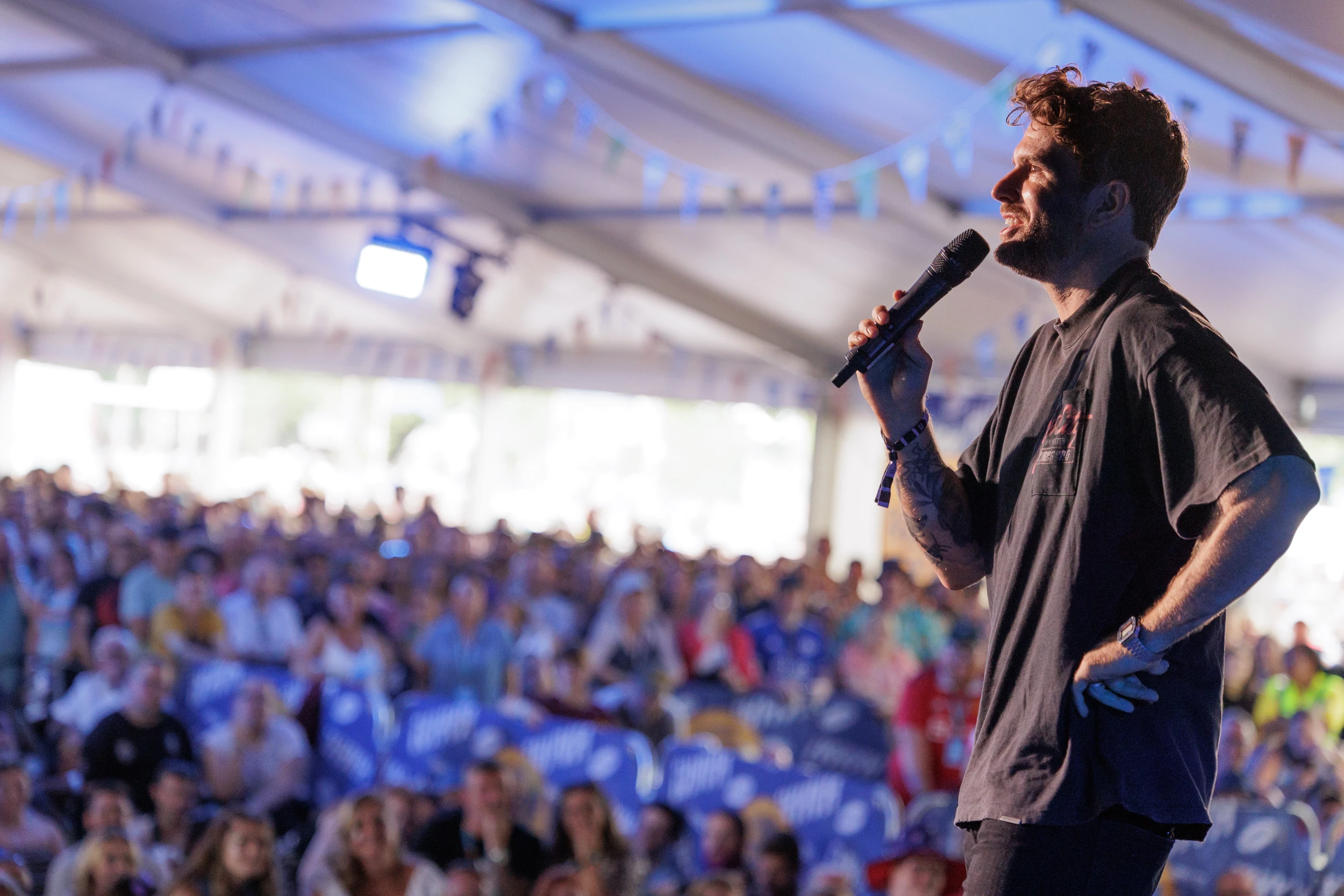 Image of comedian Joel Dommett performing in front of a crowd at Victorious Festival
