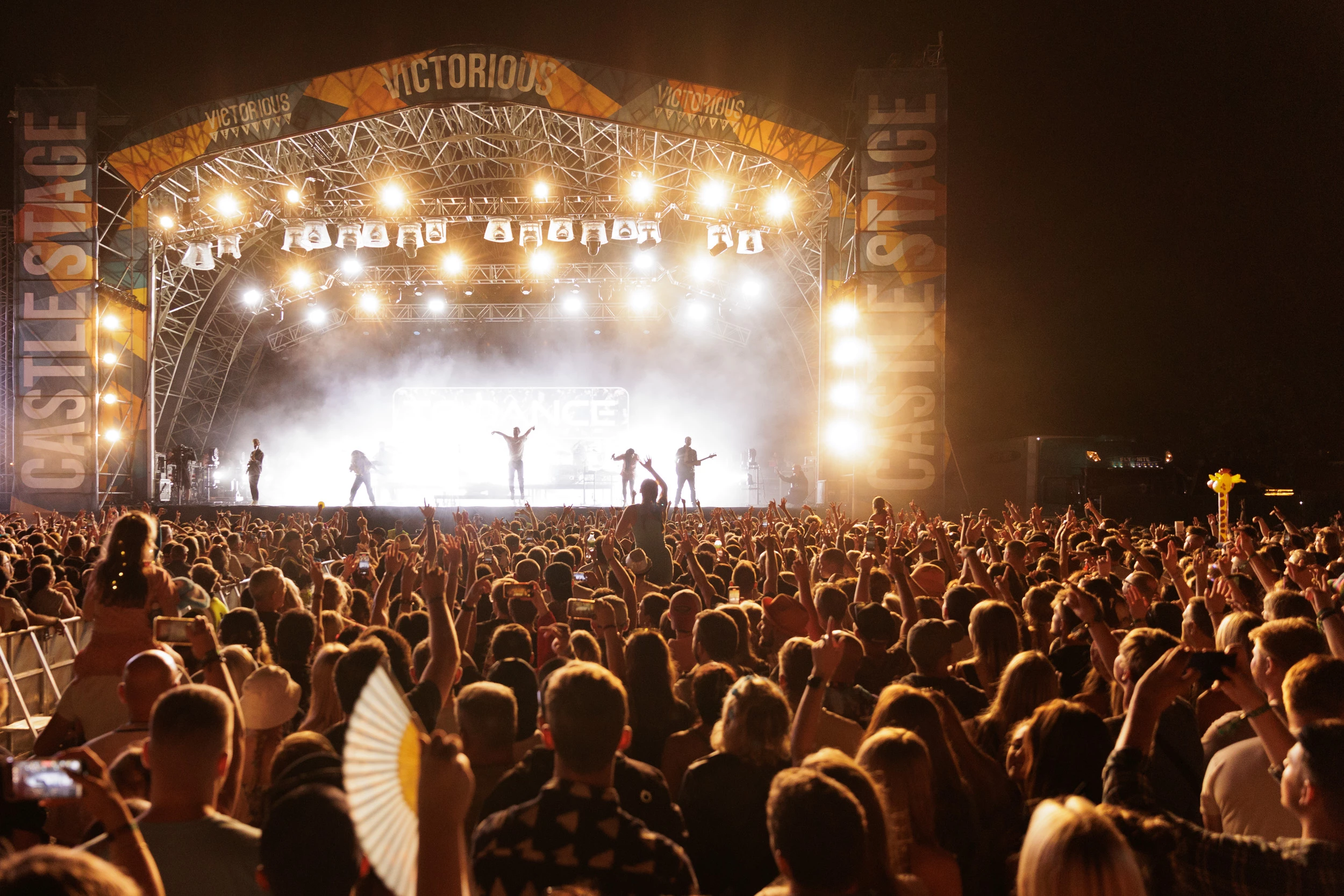 Image of crowd watching a lit up stage at night at Victorious Festival