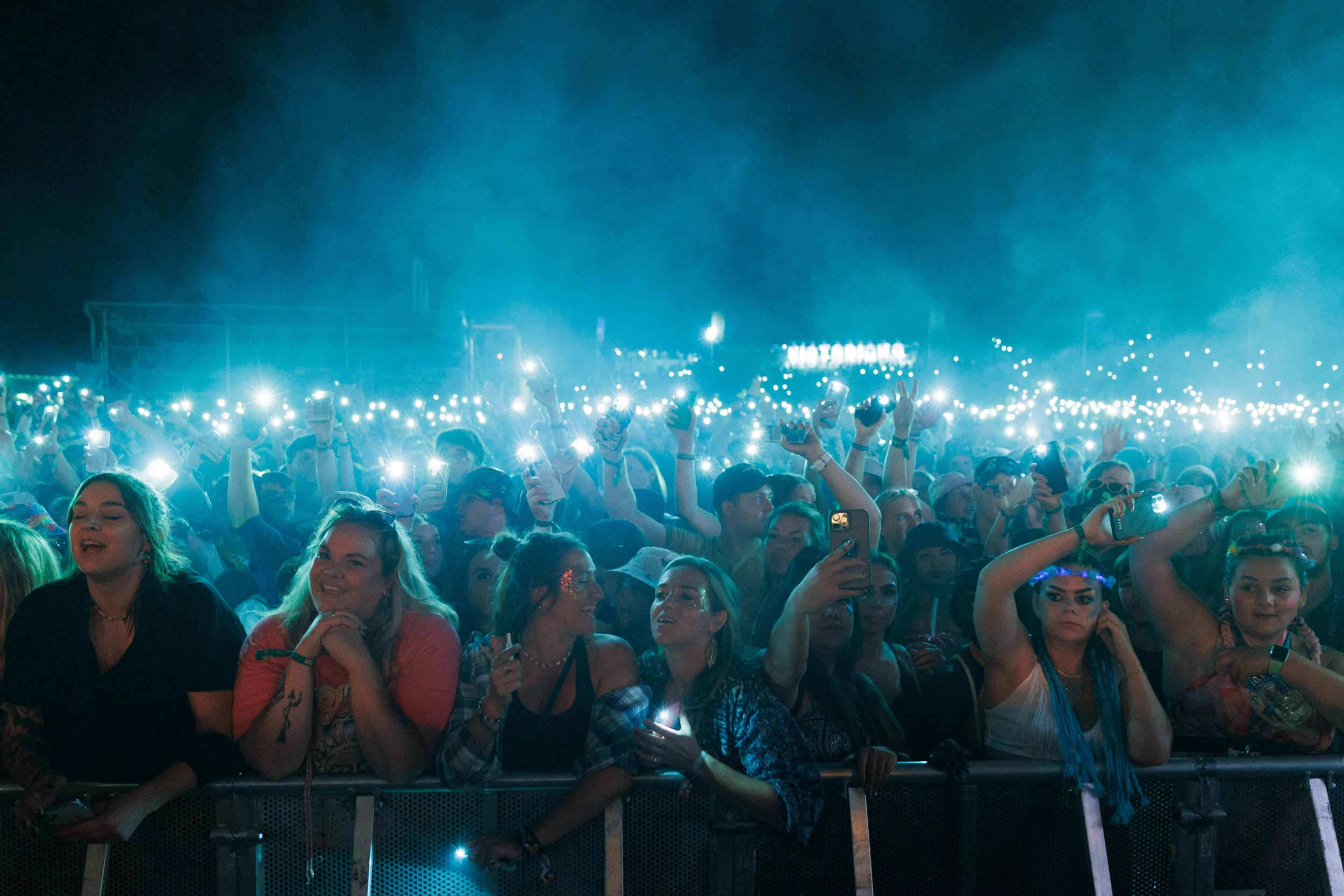 Image of front row of a crowd using phones as lights during a set at Victorious Festival