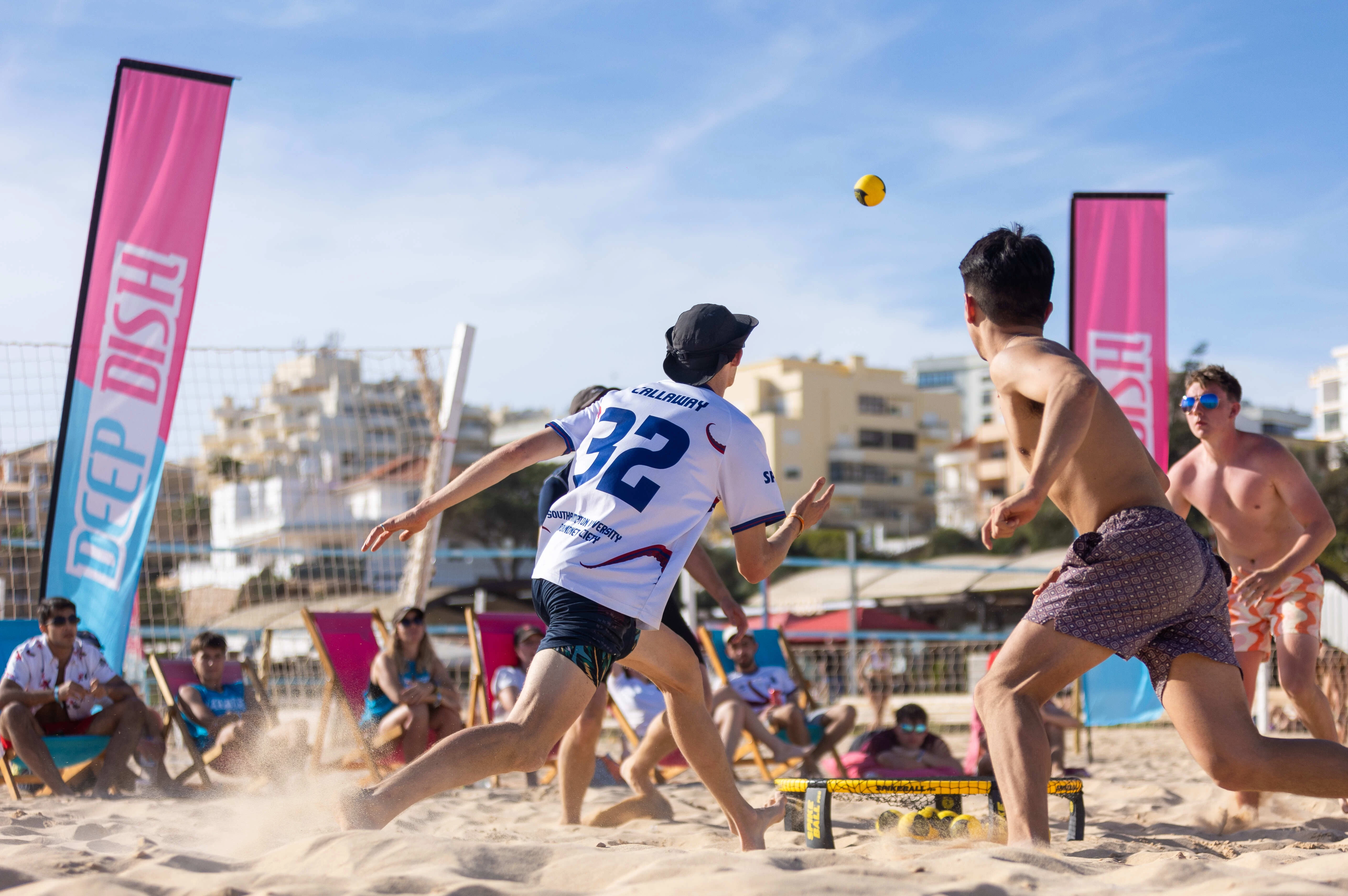 Image showing a group of people playing beach volleyball, with Deep Dish branded flags in the background