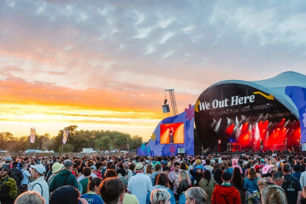 Image of crowd watching performance at the main stage of We Out Here festival during sunset